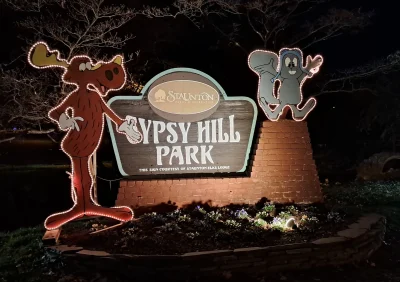 Gypsy Hill Park sign with moose and squirrel characters lit with rope lights
